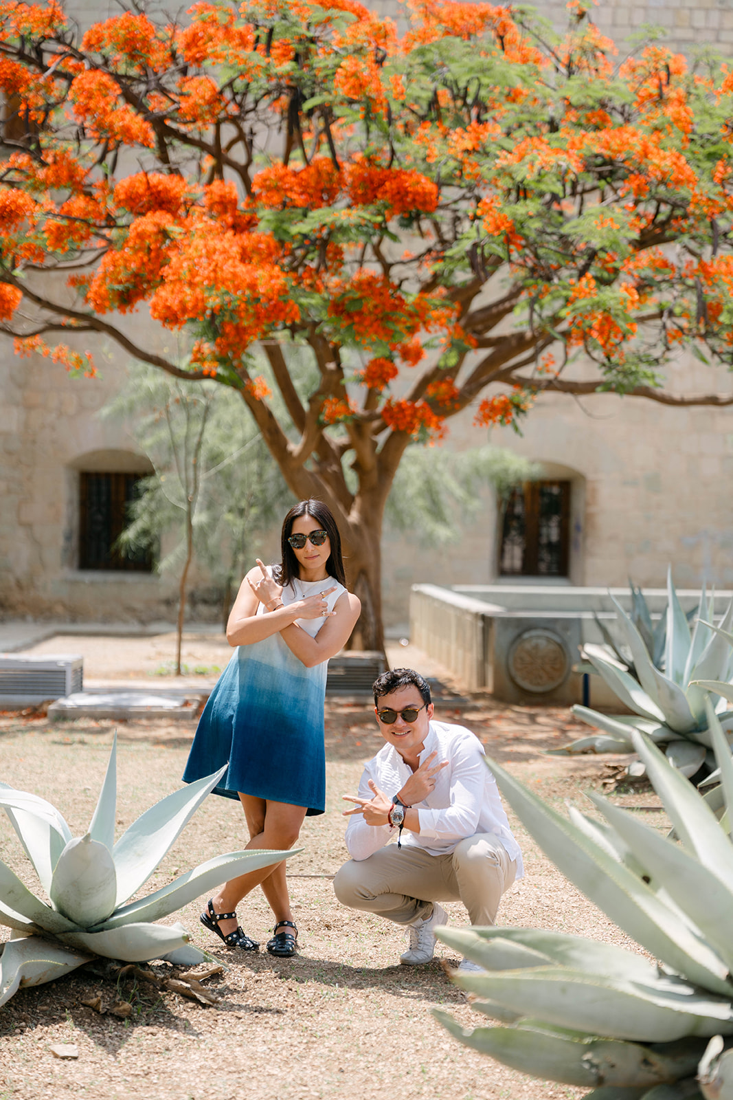 Ximena and Alexei together beneath an orange-flowering tree in Oaxaca